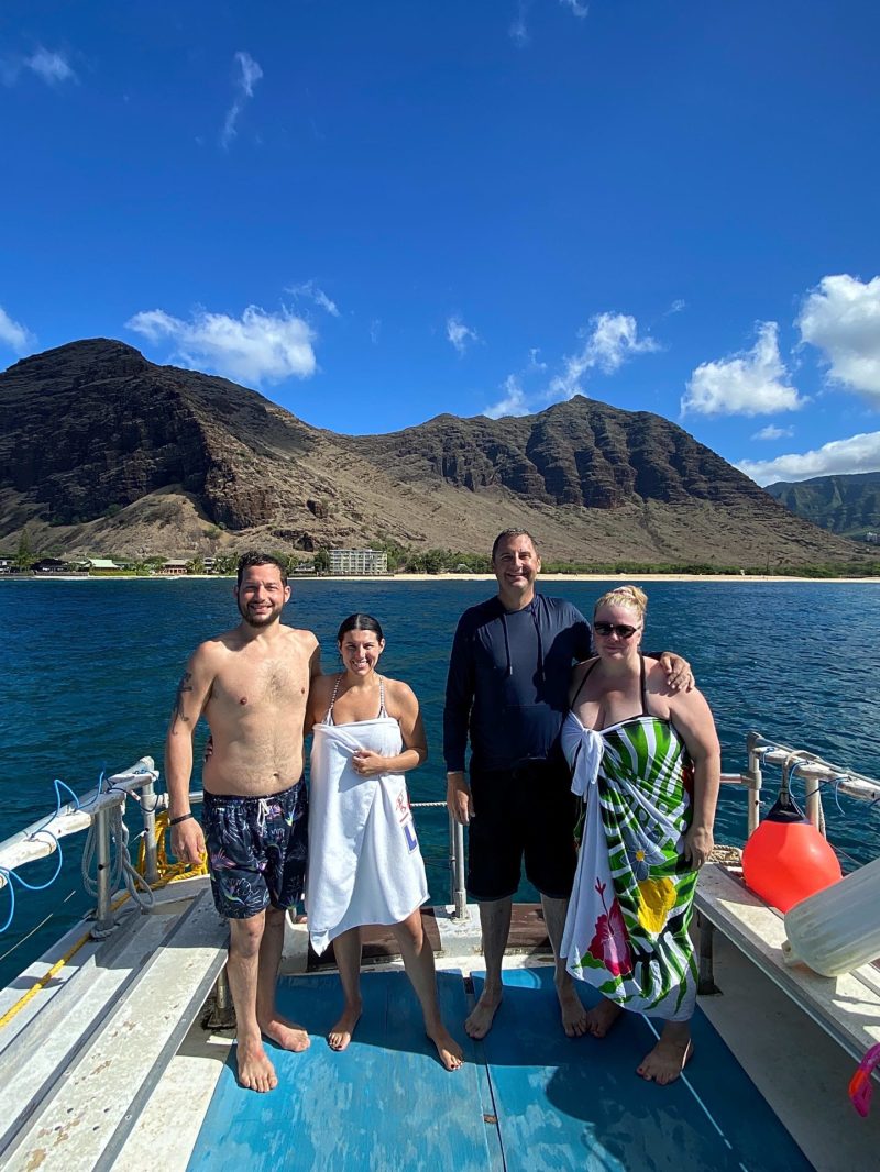 a group of people standing next to a body of water