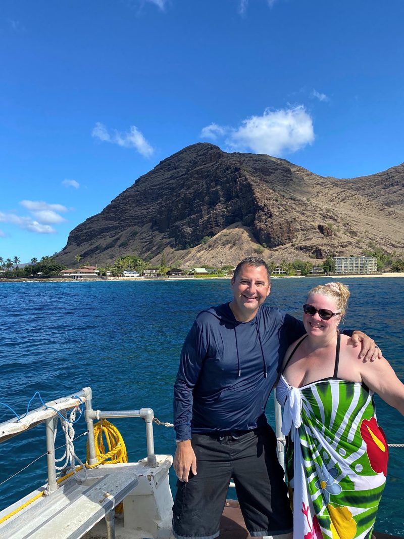 a person standing next to a body of water posing for the camera